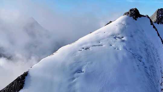 航拍攀登横断山脉乌库楚雪山山脊上的登山者