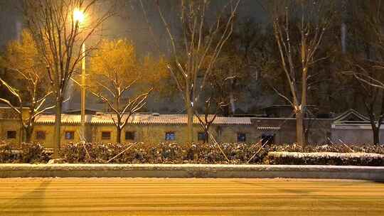 冬季下雪天夜晚路灯下的公路车流