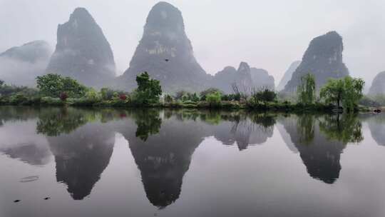 雨天湖景倒映绿树青山的宁静画面