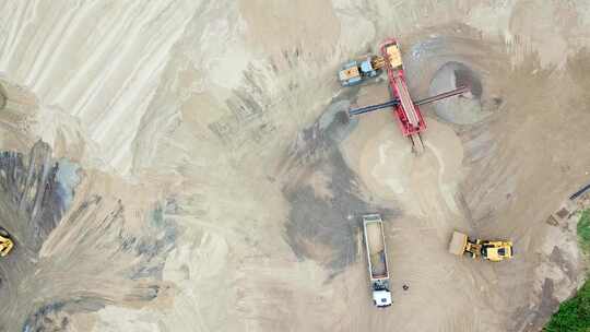 采砂场的挖掘机装载机。从上面看。带货物沙子骑行的鸟瞰翻斗车高清在线视频素材下载