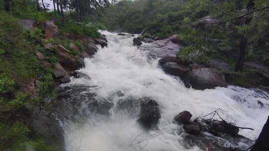 雨中看急流翻卷的小河流向远山