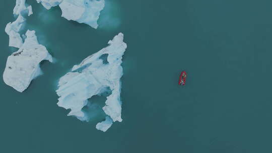探索冰岛冰川蓝色泻湖的红色旅游船。船正经过。