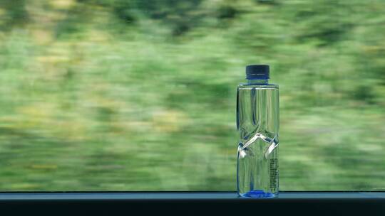高铁车窗上的矿泉水瓶，车窗外风景4k视频