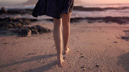 美女在沙滩上赤脚散步