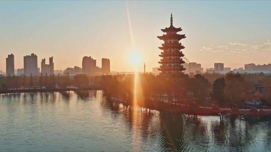 冬日蓝天日出朝阳里的城市湿地公园宝塔