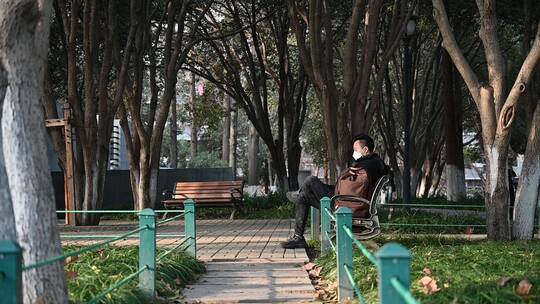 公园里男性坐着思考问题