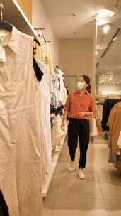 亚洲东方中国女性在商场内挑选衣服购物
