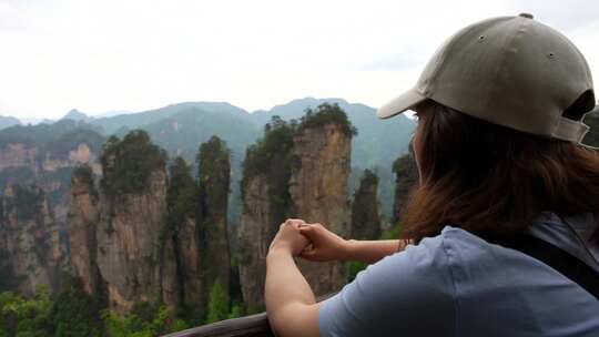 女人欣赏中国黄石村雄伟的五指峰景观