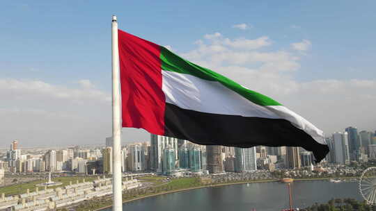 鸟瞰图：阿联酋沙迦国旗岛上空挥舞的阿拉伯联合酋长国国旗
