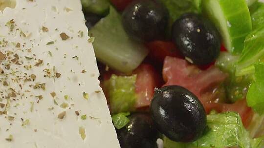 香料滴在开胃的新鲜希腊沙拉上。视频素材模板下载
