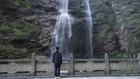 女性人物背影感受亲近自然登顶山峰瀑布水流