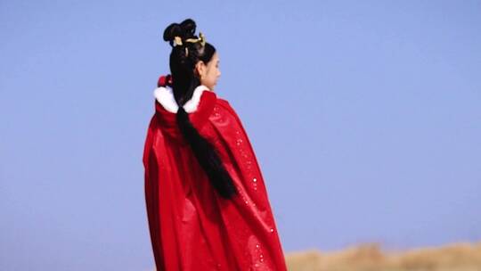 女孩身穿红色斗篷站在大漠视频素材模板下载