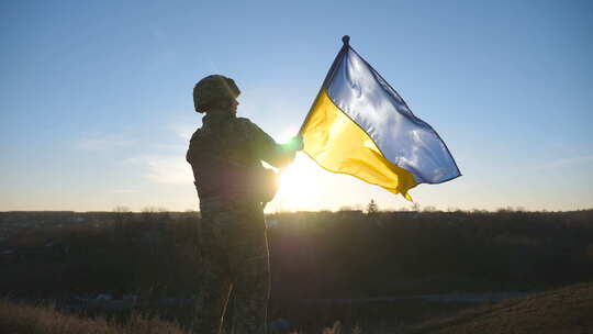 乌克兰军队士兵站在山上挥舞乌克兰国旗
