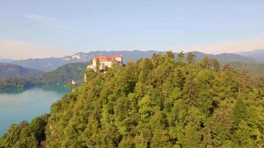 空中光滑的电影小车展示了俯瞰朱利安阿尔卑斯山布莱德湖的布莱德城堡