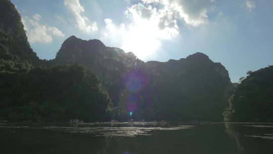 越南下龙湾小岛上的太阳和旅游船航行