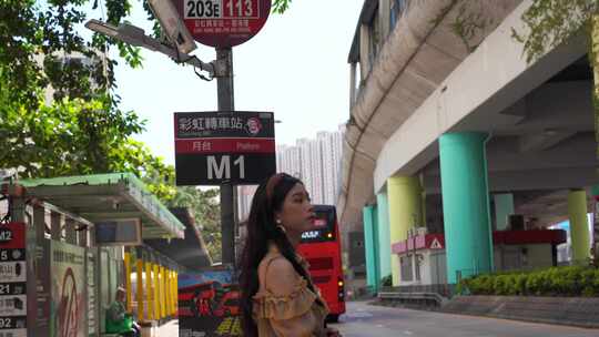 香港街头一个文艺女性青年站在公交站等巴士视频素材模板下载