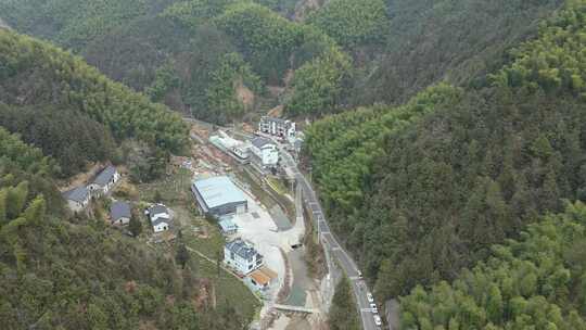 山林间的村庄及蜿蜒道路鸟瞰全景