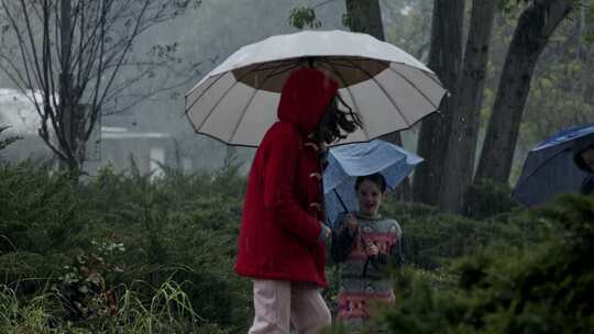 孩子们打着伞在雨中玩耍