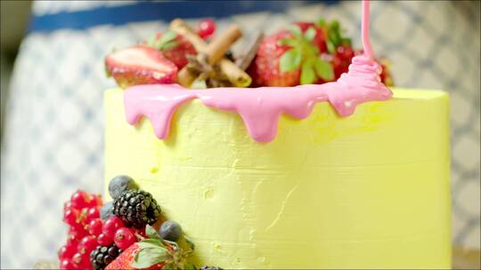 粉色奶油洒在美味的生日蛋糕上