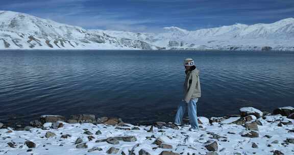 年轻女子从湖边走过徒步旅行雪山湖泊