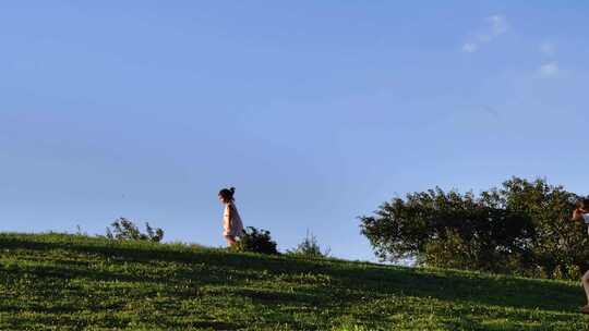 假日里草原上休闲的玩耍的小女孩