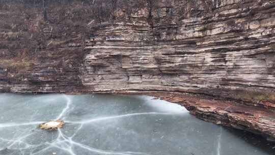 冬季山谷结冰湖面与岩壁景观