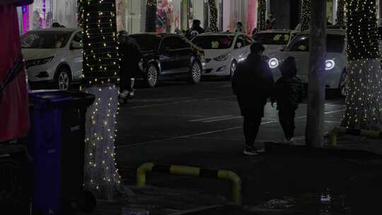 夜晚街道车流中祖孙两人相伴而行