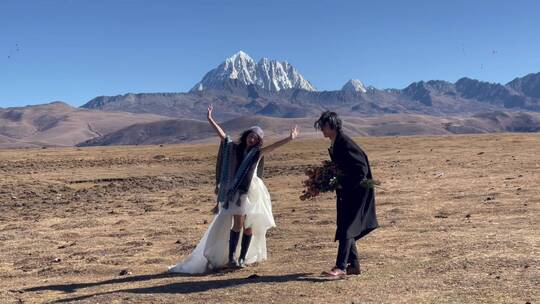 高原枯黄草原雪山情侣跳舞拍写真婚纱视频素材模板下载