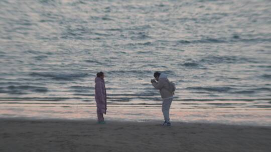 海边沙滩上拍照的情侣
