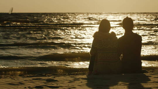 情侣坐在海边剪影