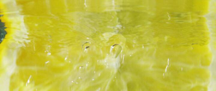 柠檬切片落入水中水面反射