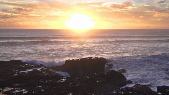 黄昏下海浪拍打岩石的镜头