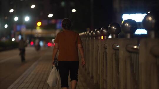 老人孤独的走在路上城市夜景