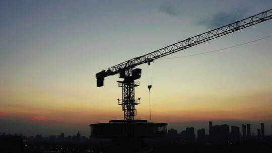 清晨日出前城市建筑工地上的塔吊