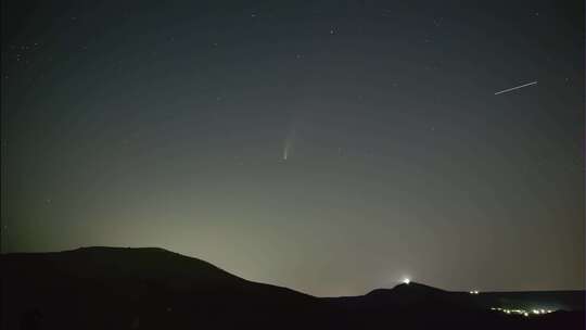 彗星在山丘和村庄上空的夜空运动延时