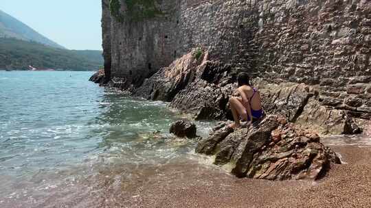 孩子们在岩石旁的海水中玩耍