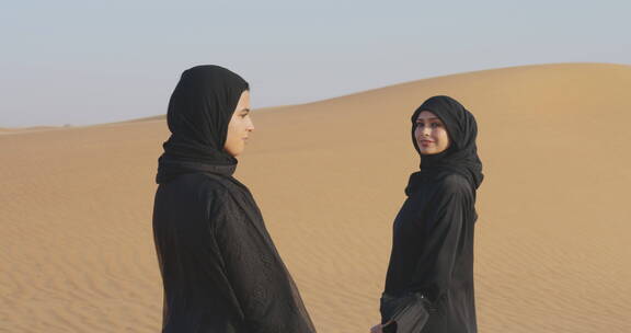 穆斯林妇女站沙漠里对着镜头微笑