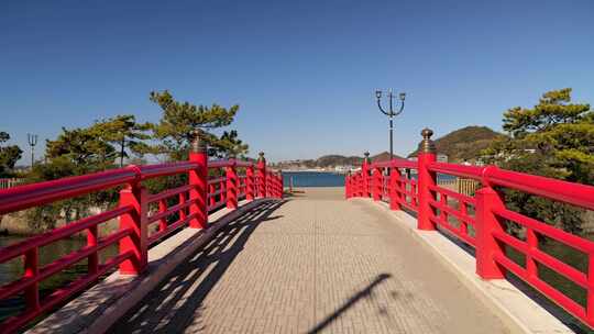 典型的红色日本木桥在蓝天晴天通向海洋