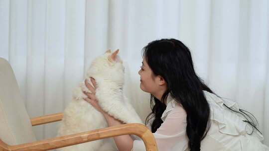 女生窗边与可爱猫咪互动玩耍