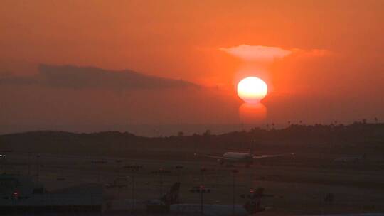 日落时分飞机在机场起飞