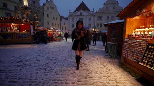 女人在冬天的雪地里走在冬天的市场上