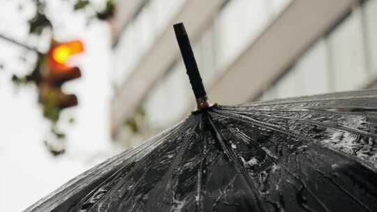 雨中欧洲城市路灯上带伞和雨衣的商人游客