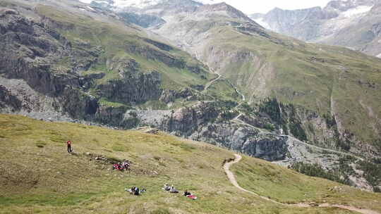 采尔马特山谷的无人机鸟瞰图，有徒步旅行路径和草地，步行者和自行车手playgr