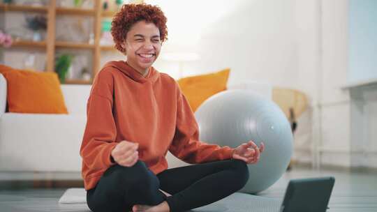 微笑的年轻成年美国妇女在瑜伽冥想姿势中坐在垫子上运动的肖像