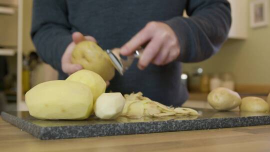 追踪厨房里剥土豆的人视频素材模板下载