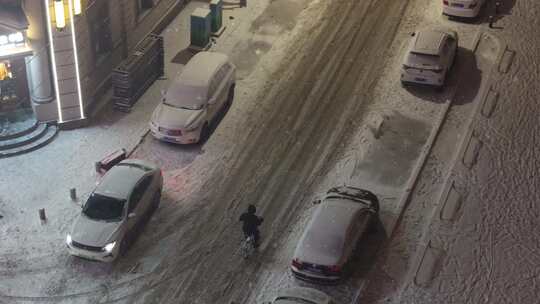 冬季东北雪夜中骑车人穿行于积雪的街道