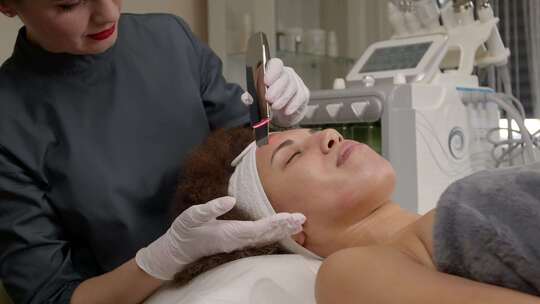 美容师用超声波皮肤洗涤器对女性进行面部护视频素材模板下载