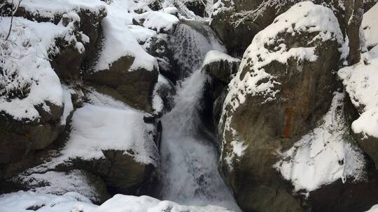 积雪的岩石之间的瀑布