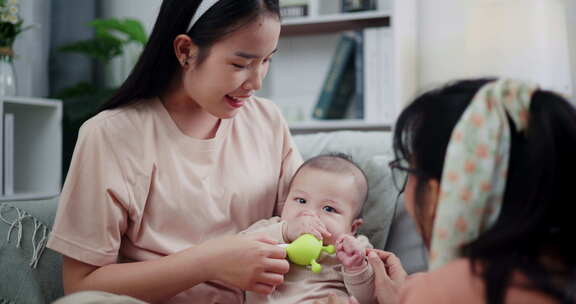 两个女人在家里客厅的沙发上开心地和一个小