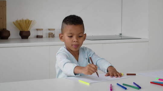 小男孩在家用彩色铅笔画画